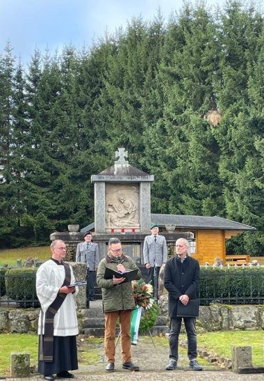 v.l.n.r.: Diakon Ewald Vogel, Bürgermeister Frederik Hohnstein, Ortsvorsteher Hermann Dentel sowie im Hintergrund die Ehrenwache der Reservistenkameradschaft Alfred Heienfeld und Helmut Frimmel
