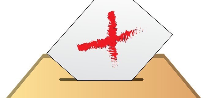 Hier sehen Sie eine Wahlurne und einen Brief, welcher auf die Breifwahl hinweist.
