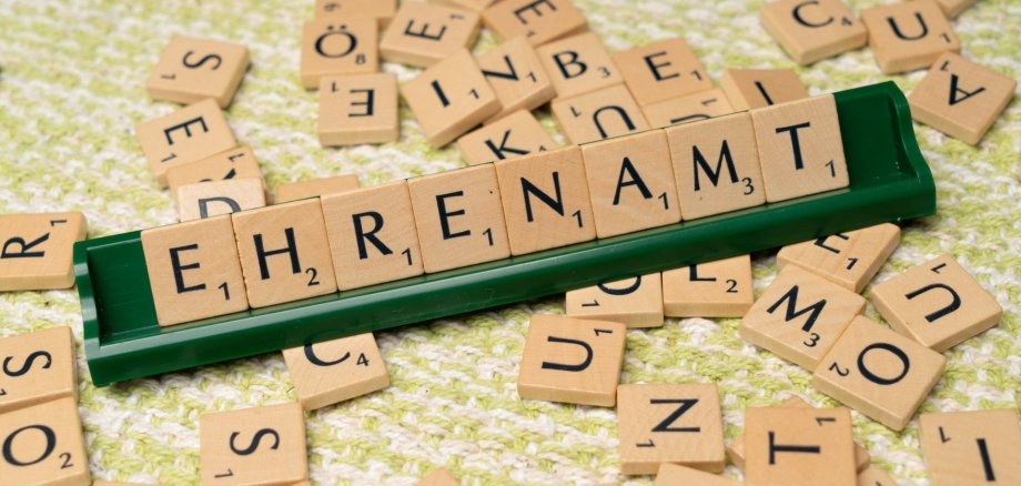 Ehrenamt Hier sehen sie das Wort "Ehrenamt" das aus Scrabble Buchstaben zusammengelegt wurde.