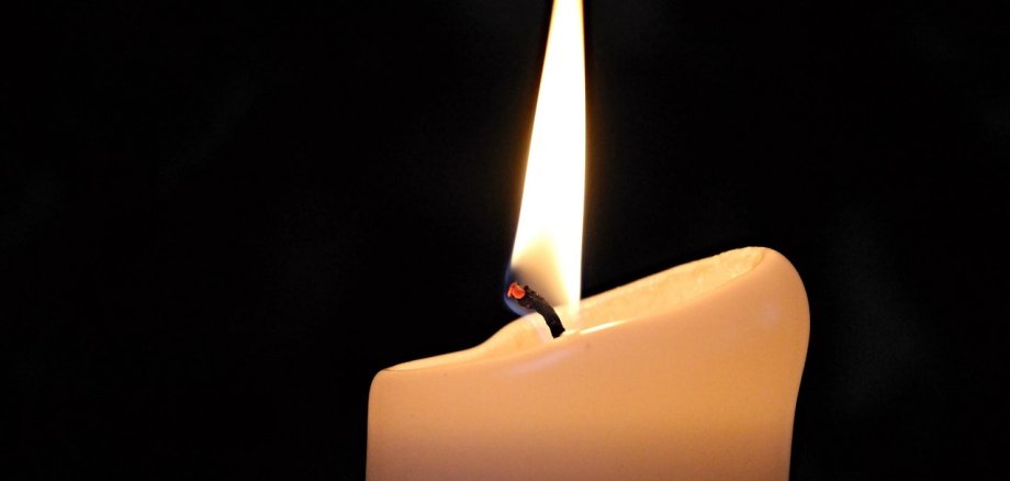 Auf diesem Bild sehen Sie eine brennende Kerze.